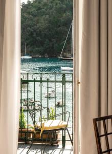 a balcony with chairs and a view of a body of water at Splendido Mare, A Belmond Hotel, Portofino in Portofino