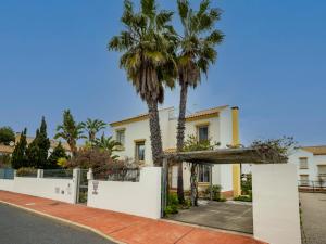 ein Haus mit Palmen und einem Zaun in der Unterkunft Chalet Sol y Mar by Ĥ in Isla Canela