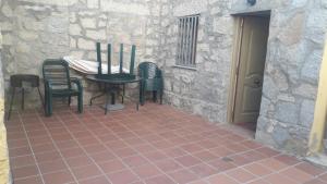 a patio with a table and chairs next to a building at Casa Rural los Portalillos II in Navatalgordo