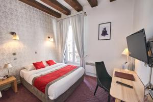 a hotel room with a bed and a desk and a television at LOGIS Hôtel Du Théâtre in Tours