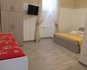 een slaapkamer met een bed en een televisie. bij MARY25 in Montescaglioso