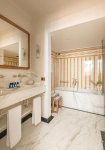 a bathroom with two sinks and a tub and a mirror at Splendido Mare, A Belmond Hotel, Portofino in Portofino