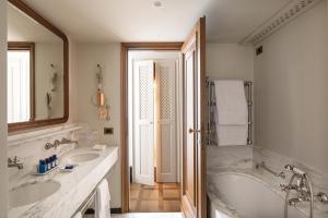 a white bathroom with two sinks and a tub at Splendido Mare, A Belmond Hotel, Portofino in Portofino