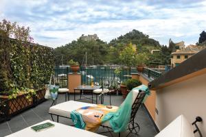 a balcony with a table and chairs on a roof at Splendido Mare, A Belmond Hotel, Portofino in Portofino