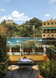 balkon ze stołem i krzesłami oraz widokiem na port w obiekcie Splendido Mare, A Belmond Hotel, Portofino w Protofino