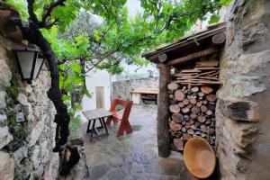 einen Innenhof mit einem Tisch und einem Stapel Holz in der Unterkunft CA JOAN a VILLORES, Els Ports (País Valencià) in Villores