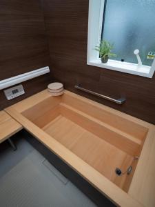 a wooden bathtub in a bathroom with a window at Kamakura International House Double Room w Shower Toilette - Vacation STAY 11408 in Kamakura