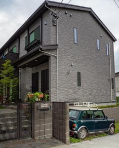 uma carrinha verde estacionada em frente a uma casa em Kamakura International House Double Room w Shower Toilette - Vacation STAY 11408 em Kamakura