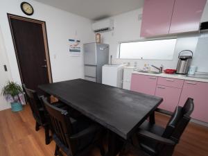 a kitchen with a black table and some pink cabinets at Kamakura International House Double Room w Shower Toilette - Vacation STAY 11408 in Kamakura