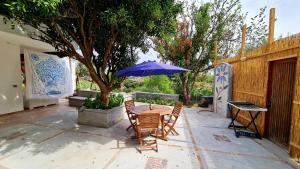 stół i krzesła z parasolem na patio w obiekcie Il Sogno w mieście Ischia