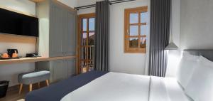 a bedroom with a bed and a desk and a window at Mellow Blue Hotel in İzmir