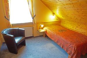ein Schlafzimmer mit einem Bett, einem Stuhl und einem Fenster in der Unterkunft Ferienwohnung Balbach,"Haus Hella" in Lauda-Königshofen