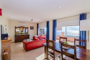 een woonkamer met een rode bank en een tafel bij Club Villamar - Denise in Lloret de Mar