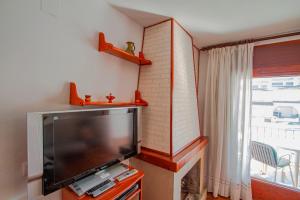 un salon avec une grande télévision à écran plat dans l'établissement Club Villamar - Palma 2, à Sant Antoni de Calonge