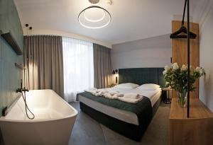 a bedroom with a bath tub and a bed and a bath tub at Hotel Alexander in Krakow