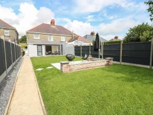 a backyard with a fence and a grass yard at Larkhill in Tenby