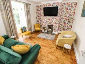 uma sala de estar com um sofá verde e uma lareira em Larkhill em Tenby