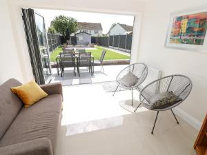sala de estar con sofá y sillas y patio en Larkhill en Tenby