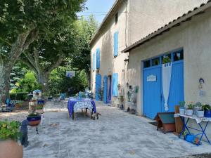 a table with a dog standing next to a building at Notre campagne provençale in Avignon