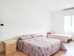 Dormitorio blanco con cama, mesa y ventana en Levico Centrale Apartment en Levico Terme