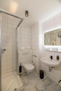 a bathroom with a toilet and a sink and a shower at Nikii City Hotel in Leverkusen