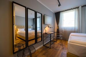 a hotel room with two beds and a mirror at Nikii City Hotel in Leverkusen