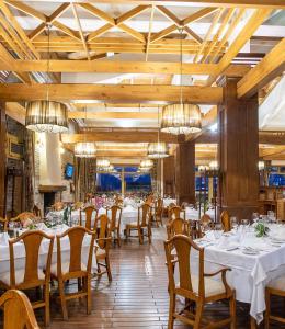 a dining room with tables and chairs and chandeliers at Pirin Golf Hotel Private Studios - Sani, Bansko in Razlog