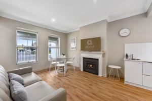 a living room with a couch and a fireplace at Aloha Central Luxury Accommodation in Naracoorte