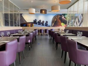 une salle à manger avec des chaises et des tables violets dans l'établissement Hotel-Restaurant Horizon Ath-Lessines, à Ghislenghien