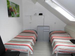 twee bedden in een kamer met een zolder bij B&B Mendelts in Emmen