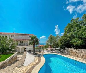 una piscina di fronte a una casa con un edificio di Apartments Villa Klaudia - Adults Only a Crikvenica