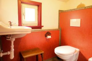La salle de bains est pourvue de toilettes blanches et d'un lavabo. dans l'établissement vakantiehuis Julia, à Bad Sachsa