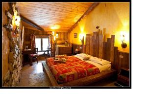 a bedroom with a large bed with a wooden ceiling at Baita La Jolie Bergere in La Salle