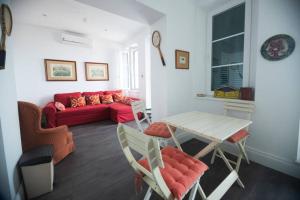 ジブラルタルにあるCharming Colonial Flat in historic buildingの赤いソファとテーブルのあるリビングルーム +13枚の写真