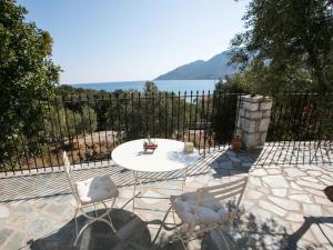 un patio con mesa y sillas y vistas al agua en MELITI, en Skoutari