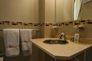 ein Badezimmer mit einem Waschbecken, einem Spiegel und Handtüchern in der Unterkunft Hotel Marbella in Buenos Aires