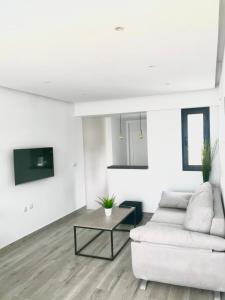 sala de estar con sofá blanco y mesa en Apartamento Loft Lucena, en Lucena