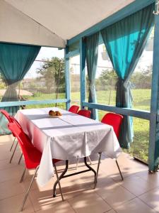 a table and chairs on a balcony with a table and blue curtains at Casa Anna in Chilia Veche