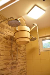 a shower in a bathroom with a stone wall at Pension U Krbu in Mikulov v Krušných Horách