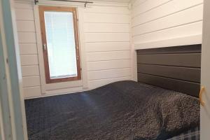 a bedroom with a bed and a window at High Rise Cottage in Muurame