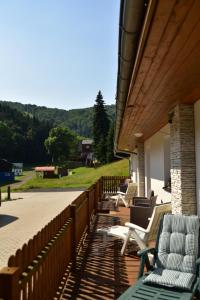 eine Reihe von Stühlen auf einer Veranda mit einem Zaun in der Unterkunft Pension U Krbu in Mikulov v Krušných Horách