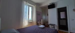 1 dormitorio con 1 cama con manta morada y ventana en La Terrazza sul Mare Affittacamere, en Monterosso al Mare
