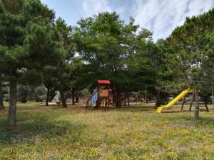 a park with a playground with a slide and trees at Casa indipendente Pavolini in Piombino