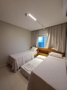 a room with two beds and a window at Salinas Exclusive Resort 2/4 até 7 pessoas in Salinópolis