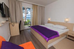 a hotel room with a bed and a balcony at Hotel Slaven in Selce