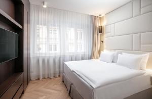 sypialnia z białym łóżkiem i telewizorem w obiekcie Rybna Apartments Old Town Prague w Pradze