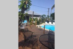 a group of chairs next to a swimming pool at Le Pluie d'Or in Saint-Louis