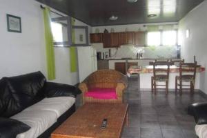 a living room with a couch and a table and a kitchen at Le Pluie d'Or in Saint-Louis