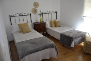 a bedroom with two beds and a table and a chair at Savala house León in León