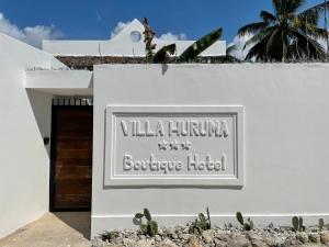 un cartello per la villa humuana boutique hotel di Villa Huruma a Paje
